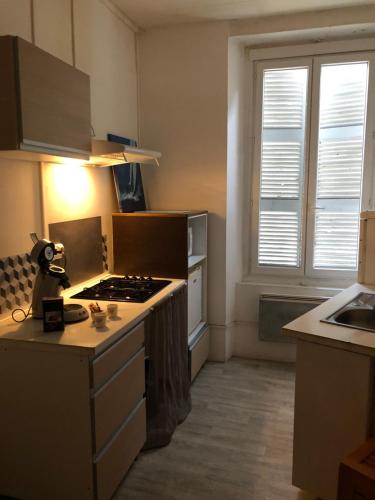 a kitchen with a stove and a sink in it at Le Victor HUGO 1G et sa pizza offerte in Aurillac