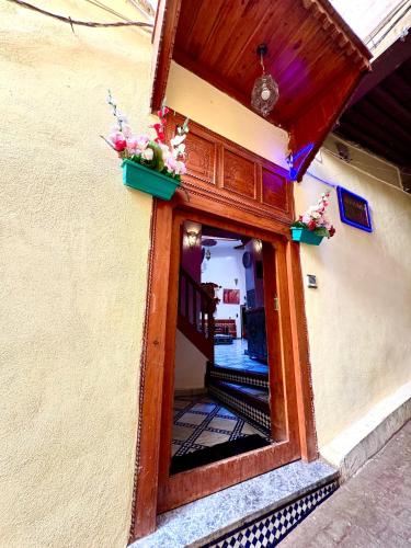 a door with flowers on the side of a building at Riad Hamad Tijani in Fès