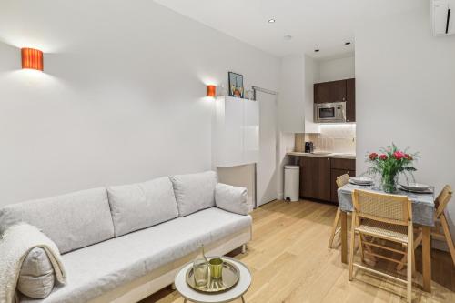 un salon avec un canapé et une cuisine dans l'établissement Lavie Maison AC and Hot Tub close Arc de Triomphe, à Paris