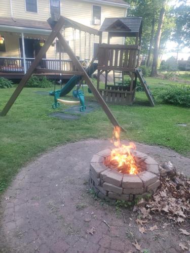 a fire pit in a yard with a playground at Attractive Lower Level Guest Suite with Private Entrance in Whitinsville