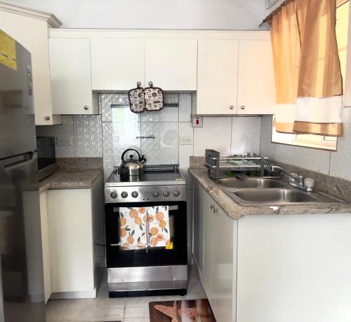 a kitchen with a stove and a sink at JIREH'S PLACE in St Mary