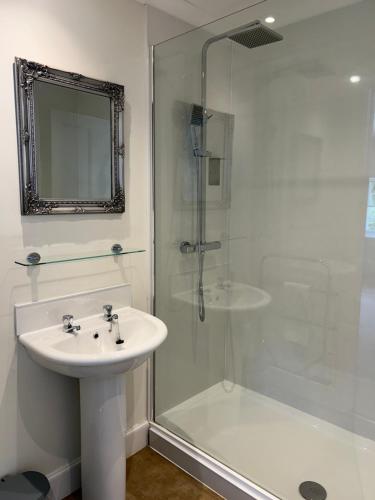 a white bathroom with a sink and a shower at Estate Of Ord in Muir of Ord