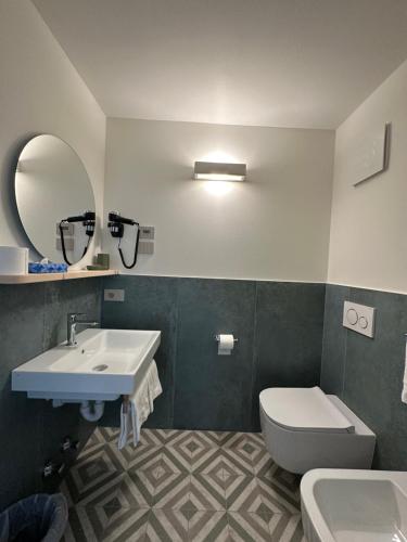 a bathroom with a sink and a toilet and a mirror at Garni La Casetta in Livigno