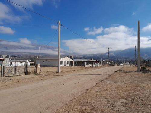 una strada sterrata vuota in una città con montagne di Cabañas Tafi a Tafí del Valle