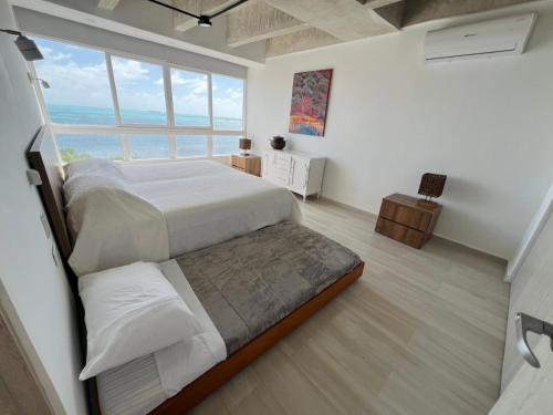 a bedroom with a large bed and a large window at Exclusivo y con vista al mar 602 in Cayo Santander