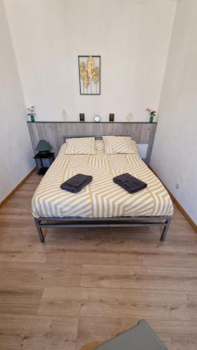 - une chambre avec un lit et des serviettes noires dans l'établissement Appartement T2 avec balcon proche centre-ville NARBONNE, à Narbonne