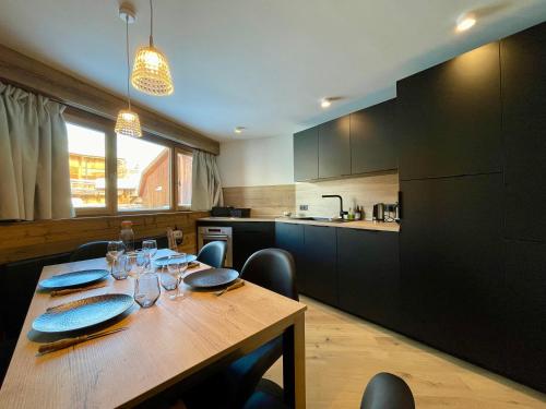 une cuisine avec une table en bois et des chaises ainsi qu'une salle à manger dans l'établissement Homency - Résidence Karen 201, à L'Alpe-d'Huez