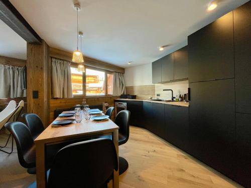 une cuisine avec une table et des chaises dans une pièce dans l'établissement Homency - Résidence Karen 201, à L'Alpe-d'Huez