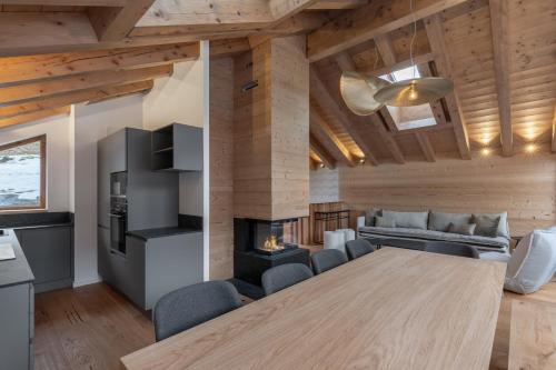 a dining room and living room with a table and a fireplace at Chalet Grand Lac in Chandon