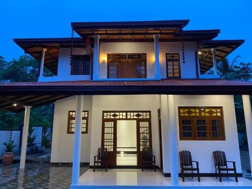 a house with chairs in front of it at night at Coco Bay Villa in Galle