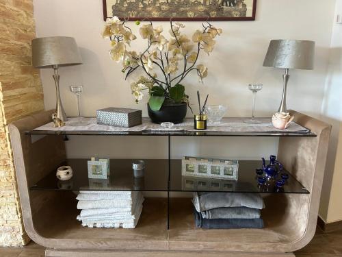 a glass shelf with two lamps and towels at Villa Somlyó in Fót