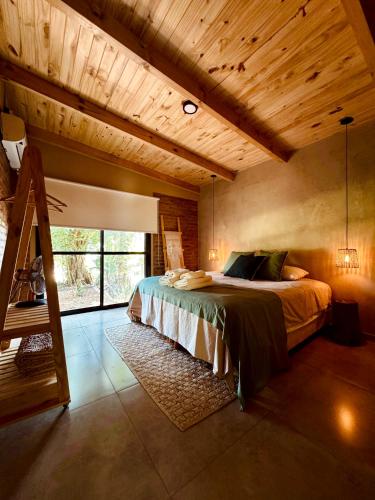 a bedroom with a bed in a room with wooden ceilings at Casa Bambú - Brisas del Lago in Puerto Bossetti