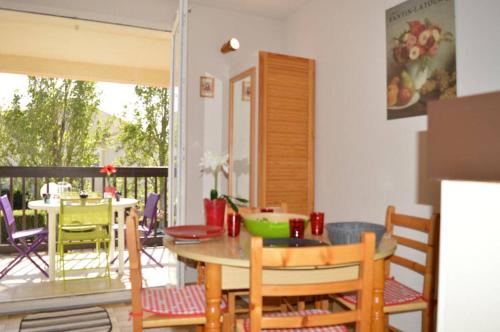 d'une cuisine avec une table et des chaises sur un balcon. dans l'établissement Appartement Studio cabine 4 couchages SAINT CYPRIEN SC070-084, à Saint Cyprien Plage