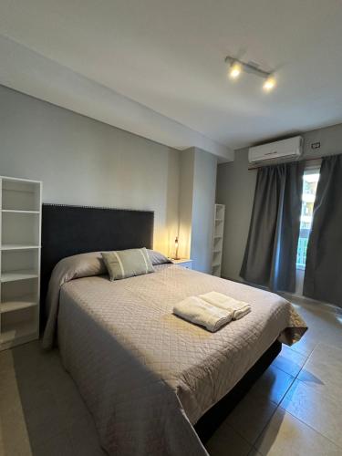 una camera da letto con un letto con due asciugamani sopra di Departamento Bitcoins House 9 de Julio a Corrientes