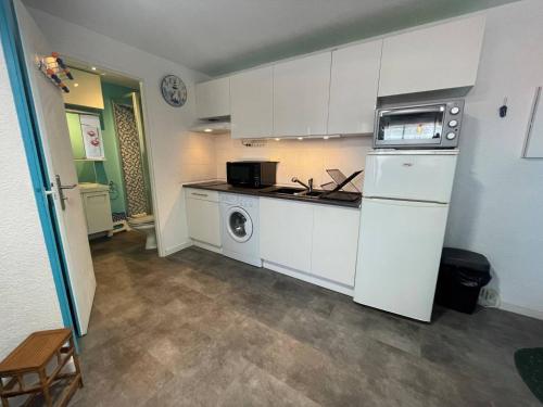 une cuisine avec des armoires blanches et une laveuse et une sécheuse dans l'établissement Appartement 2 pièces 2 couchages ST CYPRIEN PLAGE SC510-20D2, à Saint Cyprien Plage