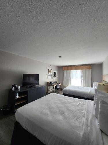 a hotel room with two beds and a television at Country Inn & Suites by Radisson, Topeka West, KS in Topeka