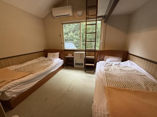 Ένα ή περισσότερα κρεβάτια σε δωμάτιο στο ペンションハウディー