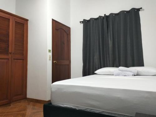 een slaapkamer met een bed met een zwart gordijn bij Vivienda turística Doña Barbara in Jardin