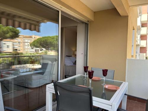 - une table en verre avec 2 verres à vin sur le balcon dans l'établissement Appartement 2 pièces CAP D 'AGDE CT160-013, au Cap d'Agde