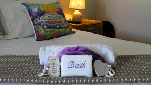 a bed with a blanket and a pillow with a birth sign at Kombi Cove Blaauwberg in Cape Town