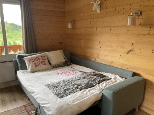 une chambre avec un lit dans un mur en bois dans l'établissement Appartement à Belle Plagne au pied des pistes, à La Plagne Tarentaise