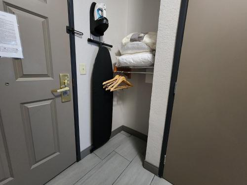 a door to a room with a closet with a coat rack at Country Inn & Suites by Radisson, Topeka West, KS in Topeka