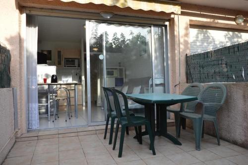 un patio avec une table et des chaises et une cuisine dans l'établissement Studio cabine Le Grau d'Agde CT245-002, au Grau-dʼAgde