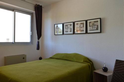 - une chambre avec un lit vert et trois photos sur le mur dans l'établissement Appt 3 pièces 6 couchages CAP D'AGDE CT275-146, au Cap d'Agde