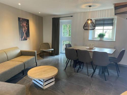 a living room with a couch and a table and chairs at Valley View 3 Atmospheric 5 person holiday home near Valkenburg in Voerendaal