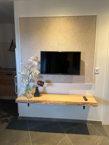 a flat screen tv on a wall with a table at Valley View 3 Atmospheric 5 person holiday home near Valkenburg in Voerendaal