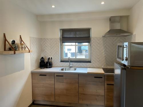 a small kitchen with a sink and a window at Sfeervolle 4 persoons cottage vlakbij Valkenburg in Voerendaal