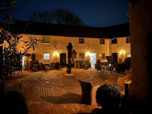- un grand bâtiment en briques avec une cour la nuit dans l'établissement Gezellige cottage bij Valkenburg, à Voerendaal