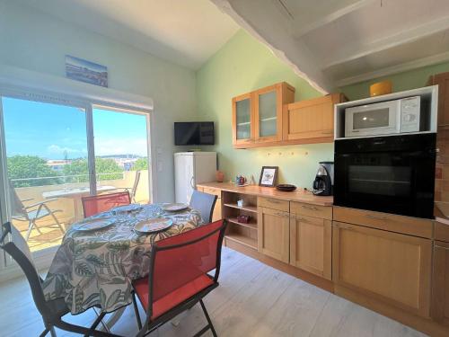 une cuisine avec une table, un four micro-ondes et une table avec des chaises dans l'établissement Studio CAP D'AGDE CT400-142, au Cap d'Agde