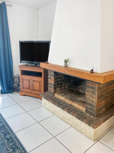 un salon avec une cheminée et une télévision dans l'établissement Maison lumineuse, jardin et Wi-Fi gratuit, à Tours