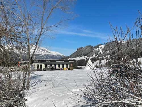 a building in the middle of a snow covered field at Holiday flat for skiing couples Triangel D - Parpan Lenzerheide in Parpan