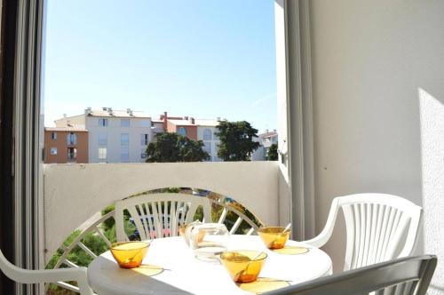 une table blanche avec des lunettes jaunes sur un balcon dans l'établissement Appt Studio 3 couchages CAP D 'AGDE CT530-011, au Cap d'Agde