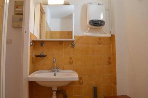 La salle de bains est pourvue d'un lavabo, d'un miroir et d'un ventilateur. dans l'établissement Appt Studio 3 couchages CAP D 'AGDE CT530-011, au Cap d'Agde