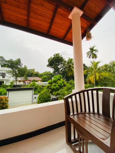 a bench on a balcony with a view of trees at Coco Bay Villa in Galle