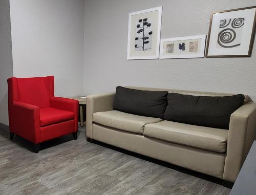 a living room with a couch and a red chair at Country Inn & Suites by Radisson, Topeka West, KS in Topeka