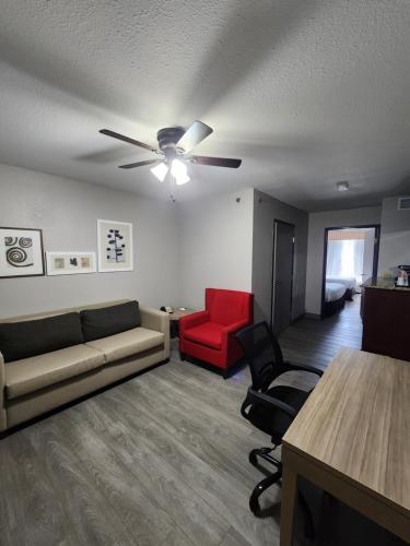 a living room with a couch and a red chair at Country Inn & Suites by Radisson, Topeka West, KS in Topeka