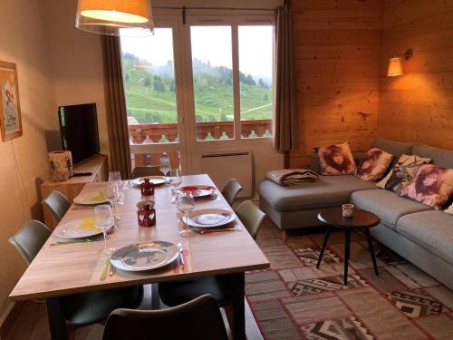 un salon avec une table et un canapé dans l'établissement Appartement à Belle Plagne au pied des pistes, à La Plagne Tarentaise