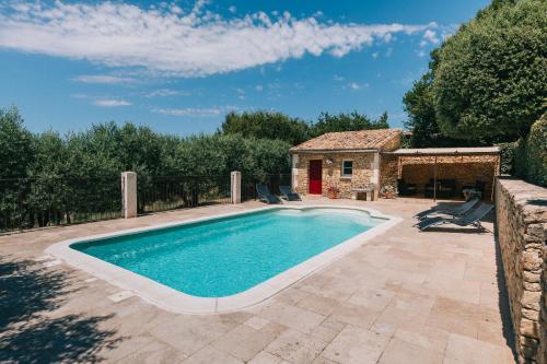 une piscine dans une cour avec une maison dans l'établissement Location vacances maison piscine LIOUX LS2-92, à Lioux