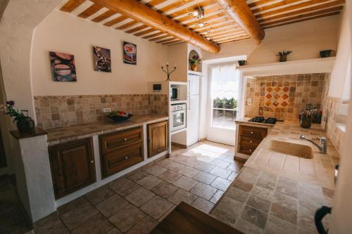 Il comprend une grande cuisine équipée d'un évier et d'une cuisinière. dans l'établissement Location vacances maison piscine LIOUX LS2-92, à Lioux