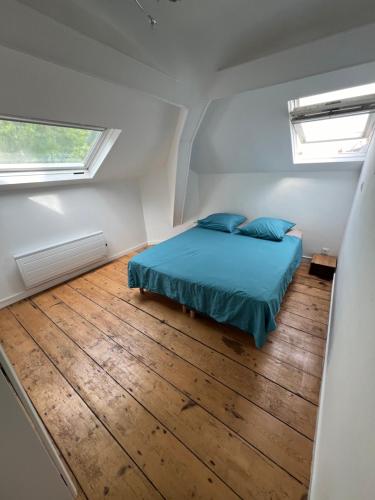 une petite chambre avec un lit et deux fenêtres dans l'établissement Magnifique 40 m2 très lumineux, calme, la mer et le centre ville tout à pieds, à Villers-sur-Mer