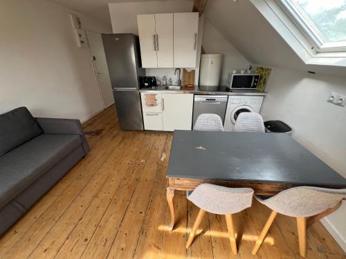 un salon avec une table et des chaises et une cuisine dans l'établissement Magnifique 40 m2 très lumineux, calme, la mer et le centre ville tout à pieds, à Villers-sur-Mer