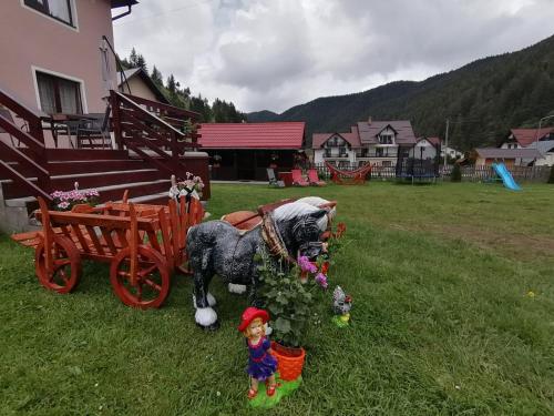 a statue of a horse pulling a cart with a doll at Vila Nico 2 in Moieciu de Sus
