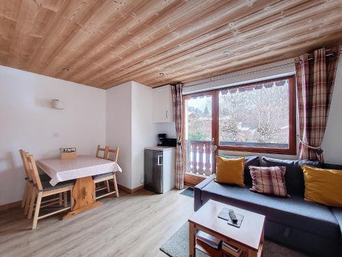 un salon avec un canapé bleu et une table dans l'établissement APPARTEMENT 6 COUCHAGES - ST JEAN D'AULPS - PROCHE PIED DES PISTES - PROCHE MORZINE - Cimes 44, à Saint-Jean-dʼAulps