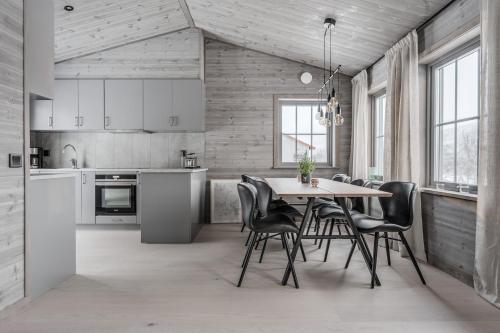 a kitchen and dining room with a table and chairs at Bastuvallen - Ramundberget in Bruksvallarna