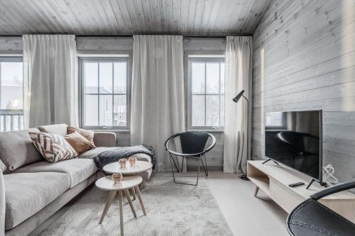 a living room with a couch and a tv at Bastuvallen - Ramundberget in Bruksvallarna