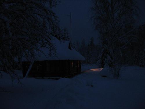 a cabin in the snow at night at Kikepera Alamaja in Parnumaa